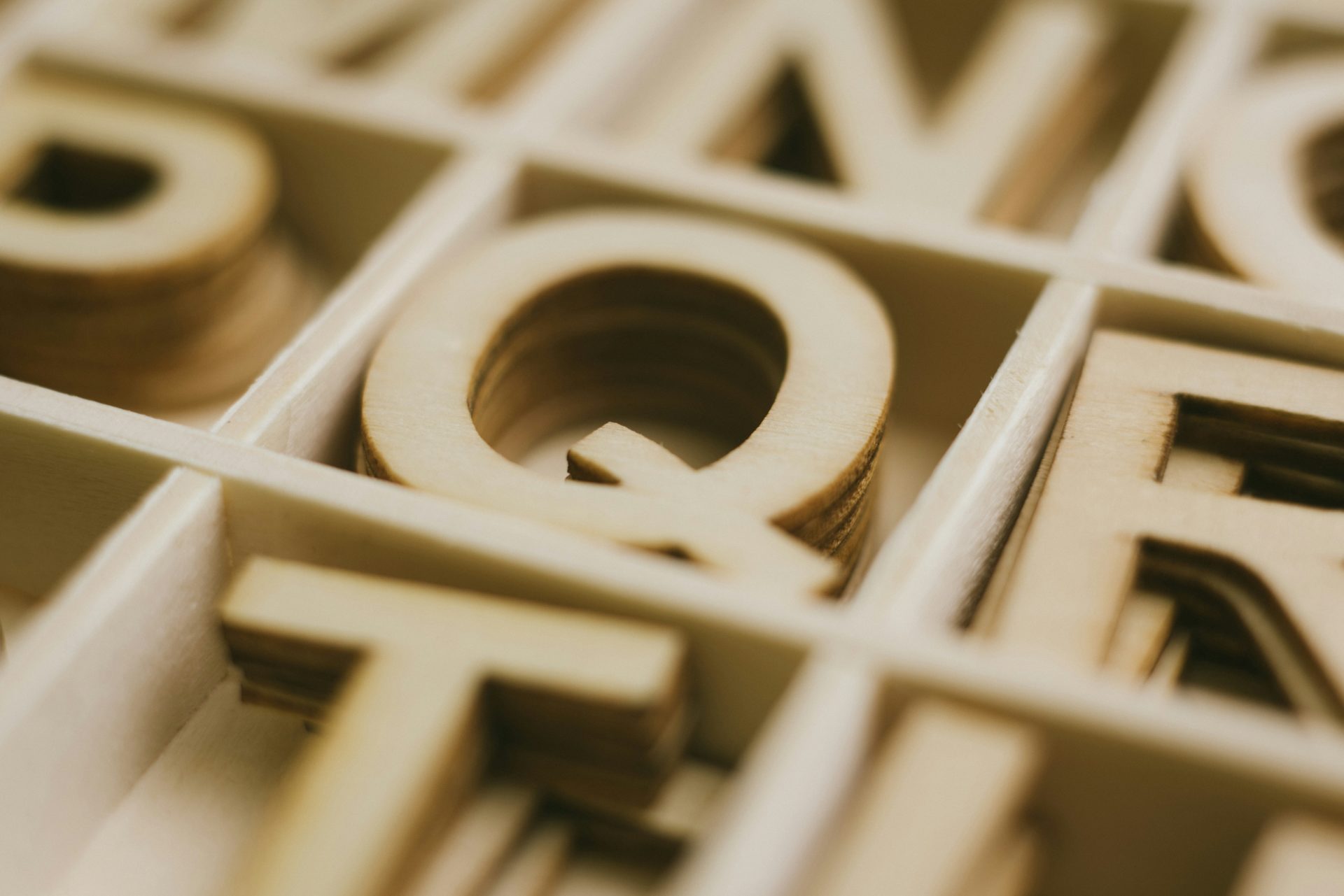 A letter Q made from wood as part of a puzzle with letters